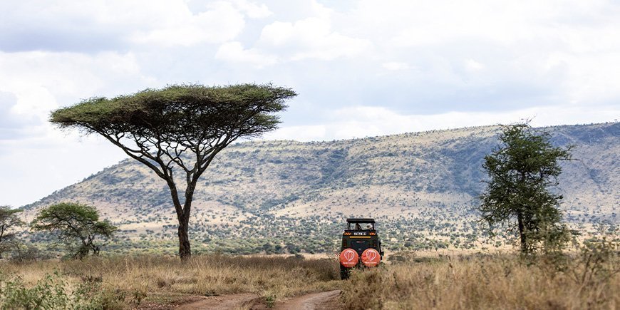 Safari-Jeep fahren in der Landschaft Tansanias