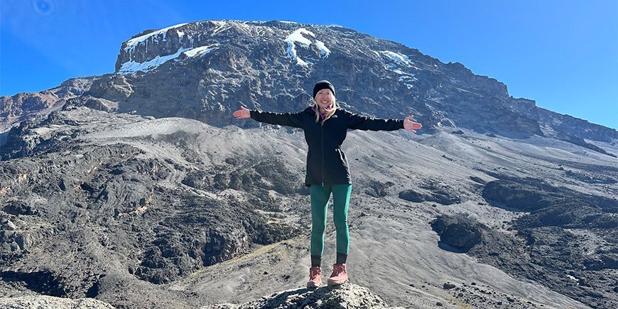 Catriona steht mit Blick auf die wilden Landschaften des Kilimanjaro