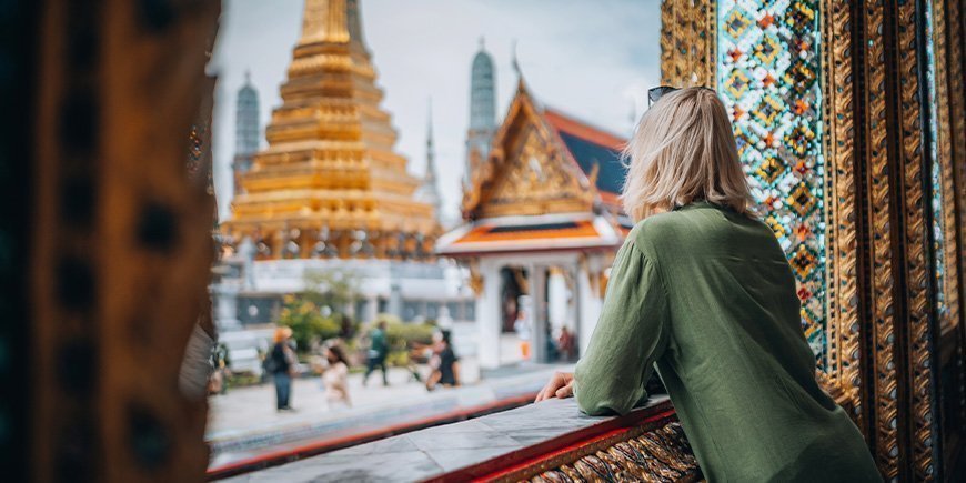 Frau mit Blick auf einen Tempel in Bangkok, Thailand