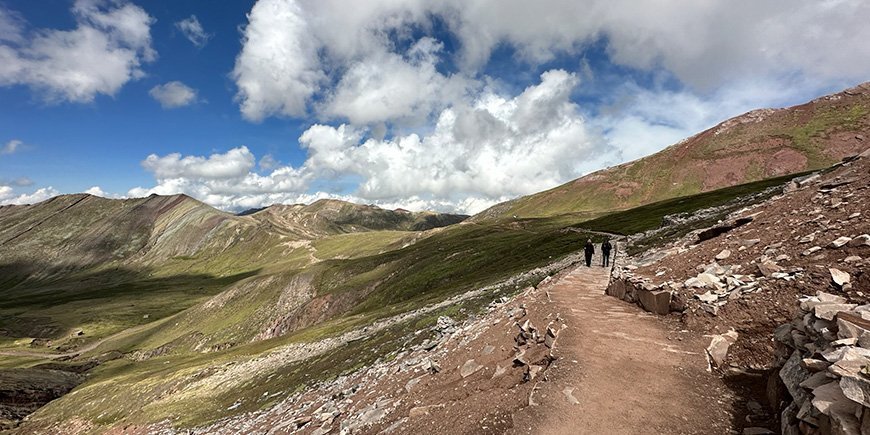 Zwei Menschen wandern auf dem Regenbogenberg in Peru