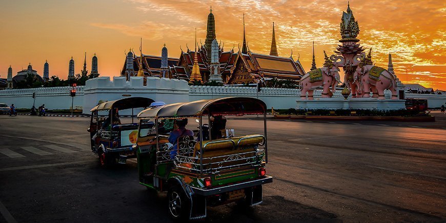 Tuk Tuk mit Blick auf einen Tempel in Bangkok