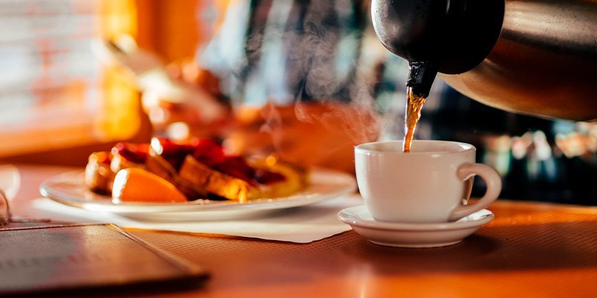 Mann sitzt in einem Diner, isst Waffeln und trinkt Kaffee