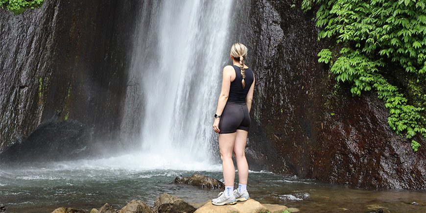 Louisa steht vor dem Red Coral Wasserfall