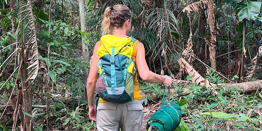 Jude beim Wandern mit ihrem Schlafsack im Amazonas-Dschungel